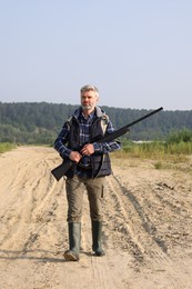 Photo of Man with hunting rifle outdoors. Open season
