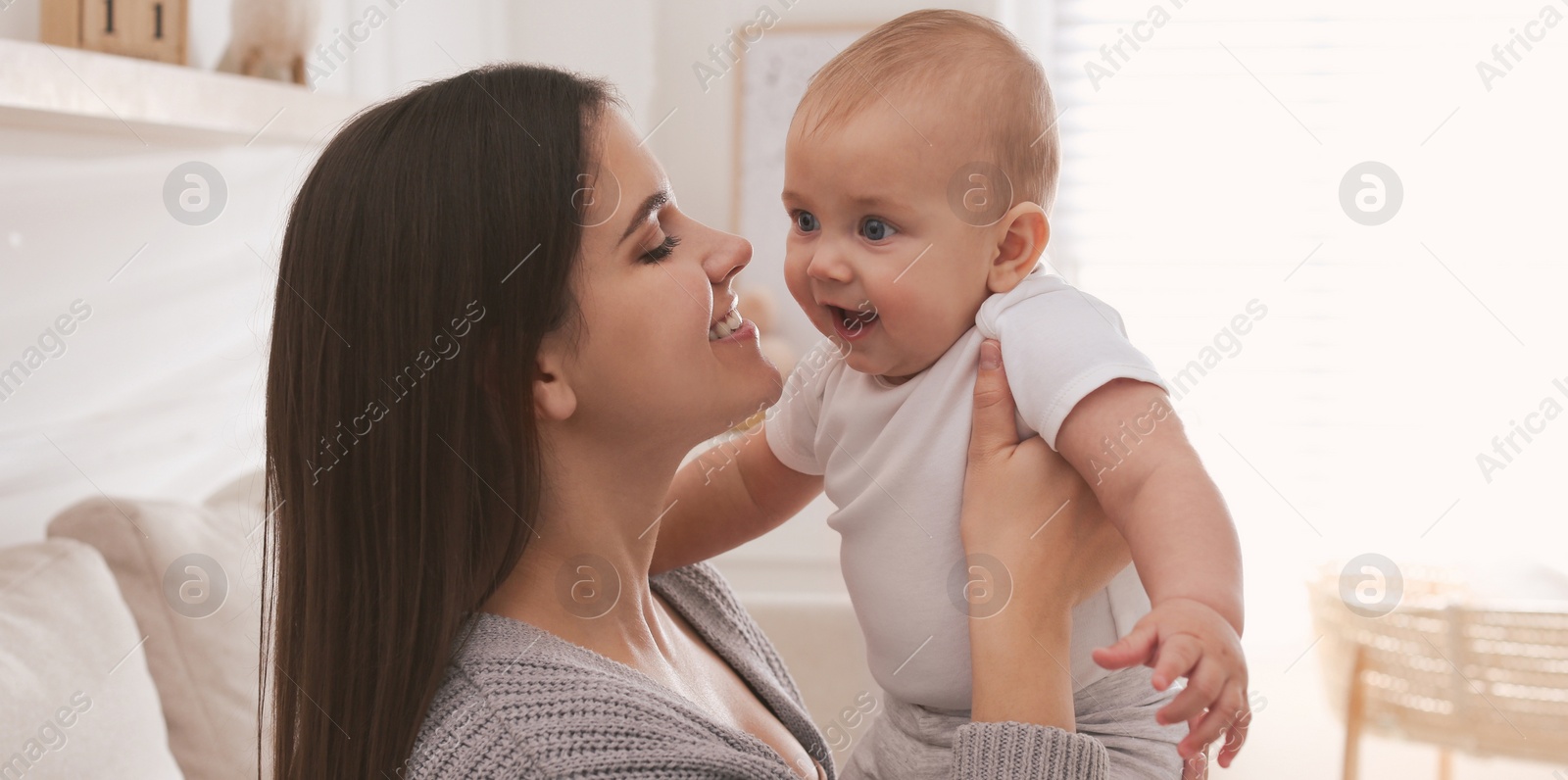 Image of Happy young mother with her cute baby at home. Banner design 