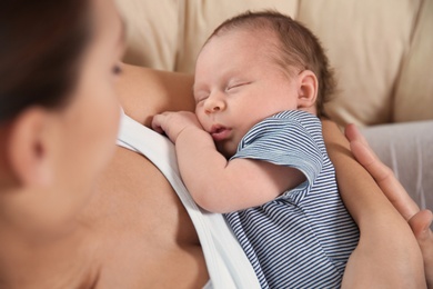 Young woman holding her newborn baby, closeup