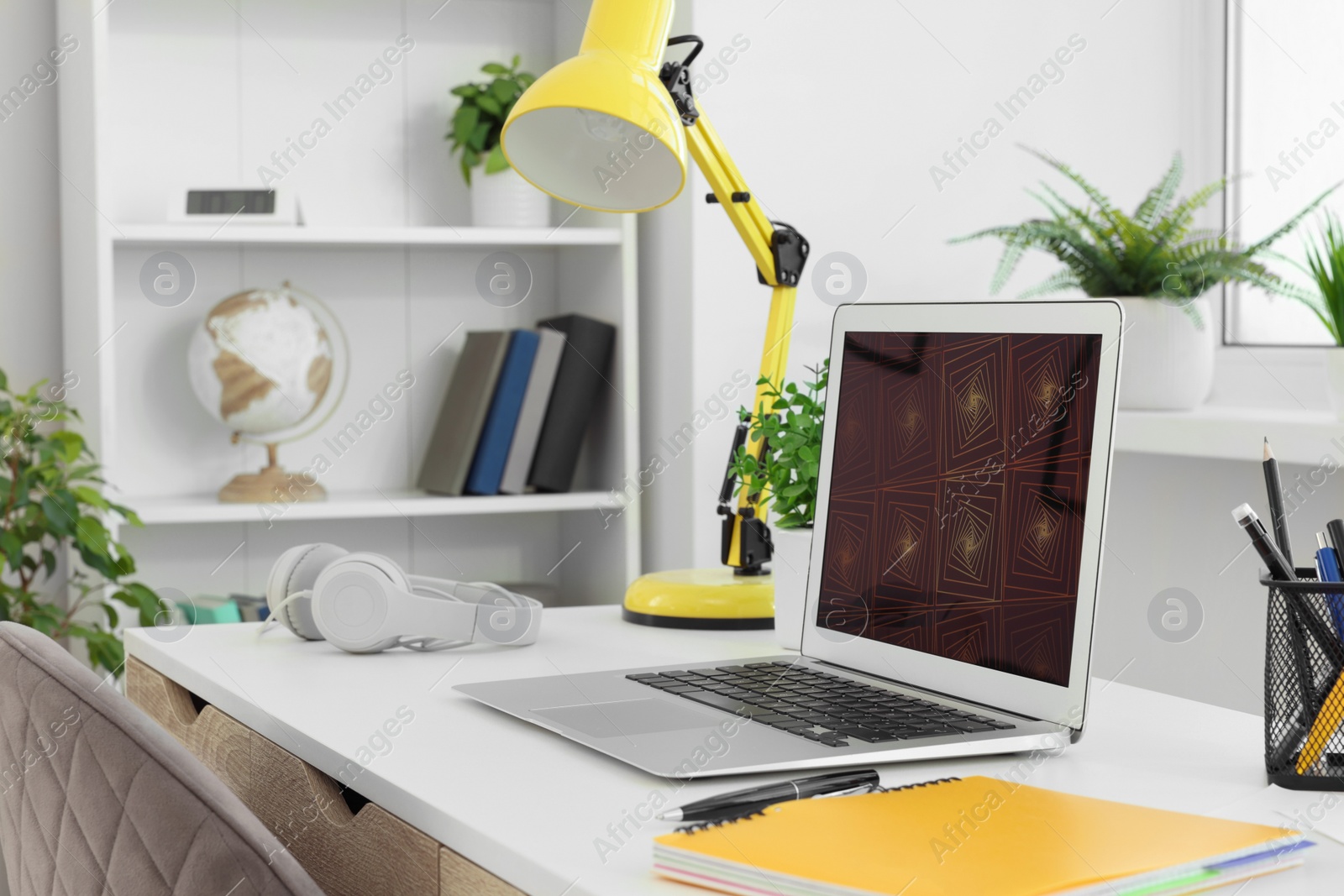 Photo of Cozy workspace with laptop on white wooden desk at home