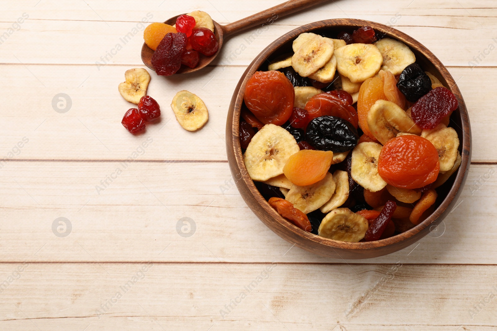 Photo of Mix of delicious dried fruits on white wooden table, flat lay. Space for text