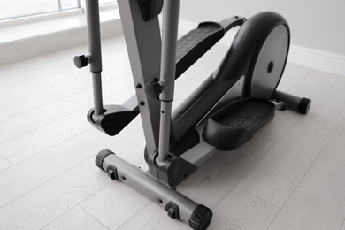 Photo of Modern elliptical machine cross trainer on floor indoors