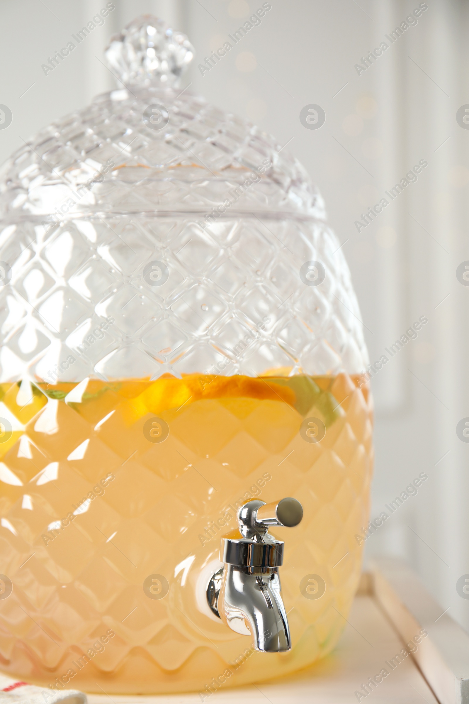 Photo of Beverage dispenser with delicious refreshing drink on table