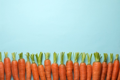 Photo of Flat lay composition with fresh carrots on color background. Space for text