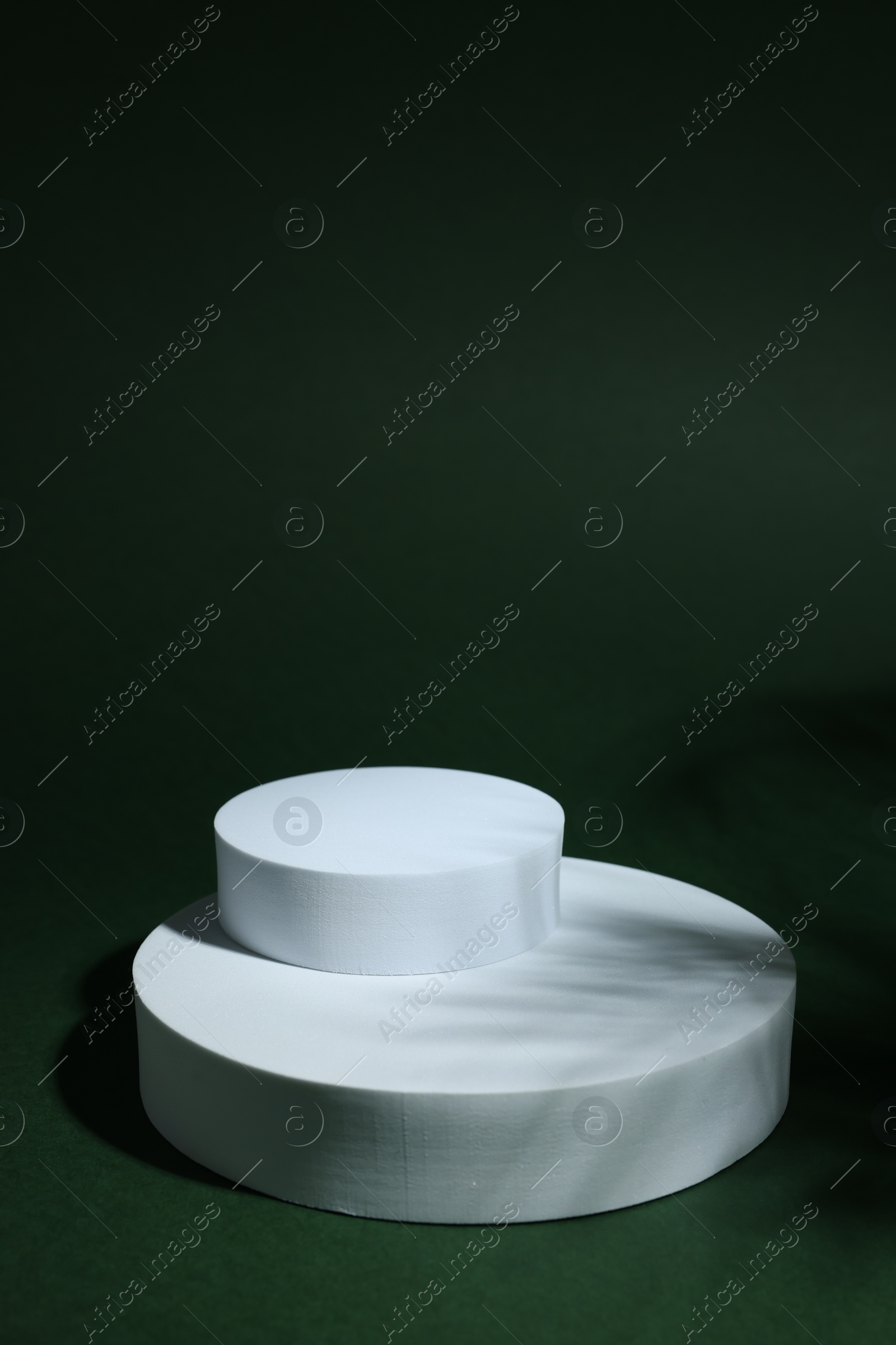 Photo of Product photography props. Round shaped podiums on green background, space for text