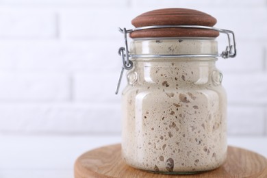 Photo of Sourdough starter in glass jar on table, space for text