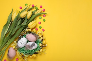 Flat lay composition with beautiful flowers and eggs on yellow background space for text. Easter celebration