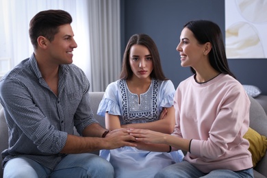 Unhappy woman feeling jealous while couple spending time together at home