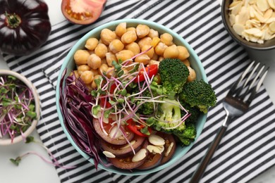 Delicious vegan bowl with broccoli, red cabbage and chickpeas on white table, flat lay