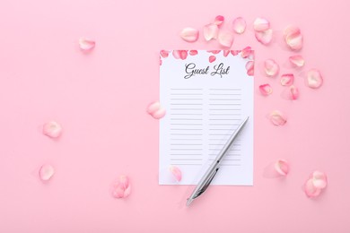 Guest list, pen and petals on pink background, flat lay. Space for text