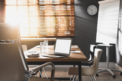 Photo of Laptop on wooden table in modern office