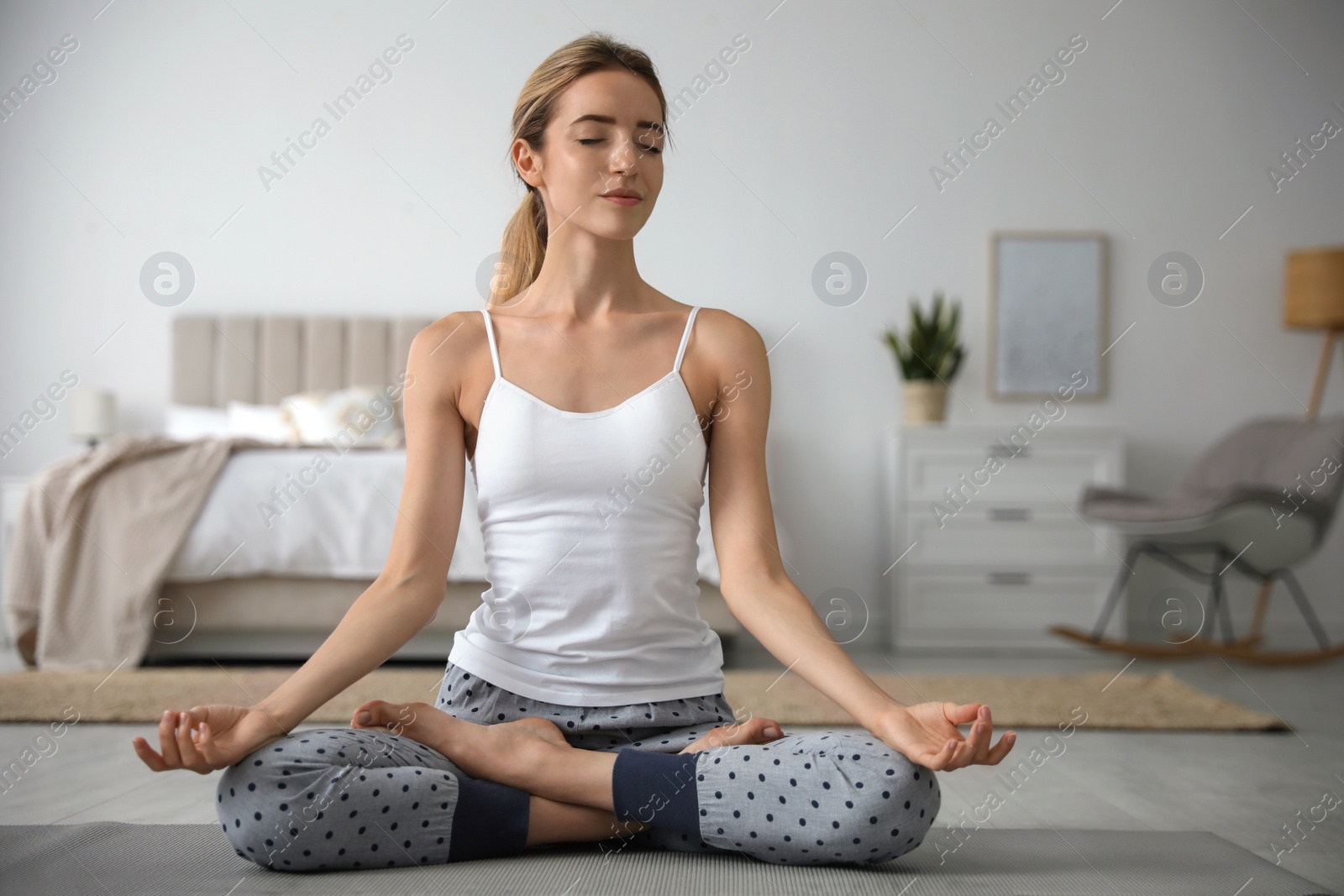 Photo of Young woman meditating on floor at home. Morning fitness