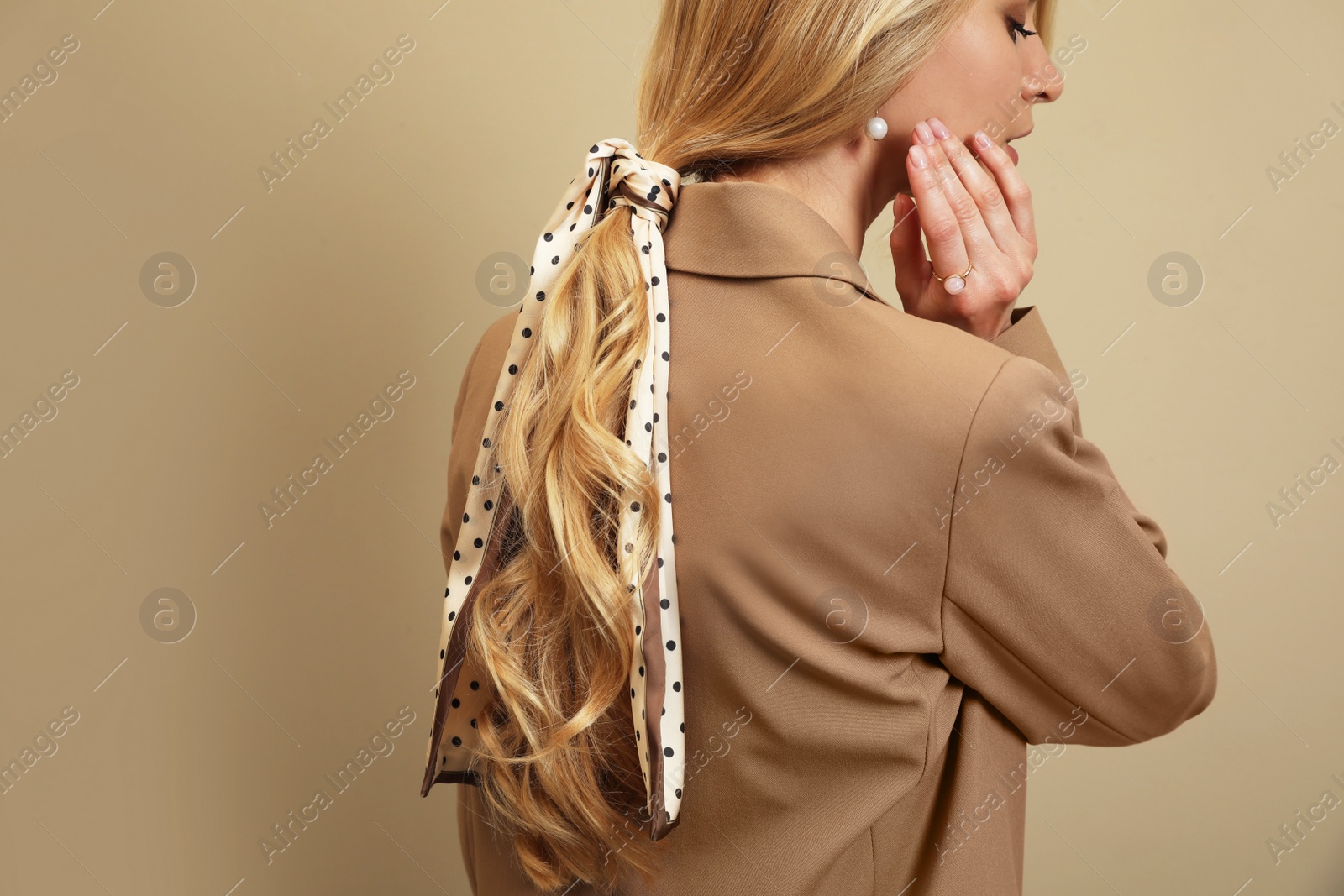 Photo of Young woman with stylish bandana on beige background