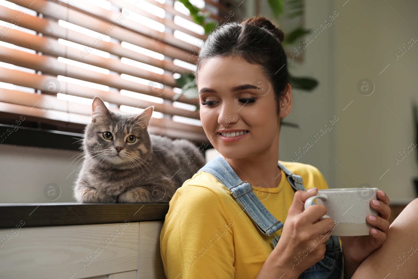 Photo of Young woman with cute cat at home. Pet and owner