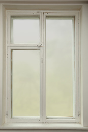 Photo of Old white window with wooden sill in room