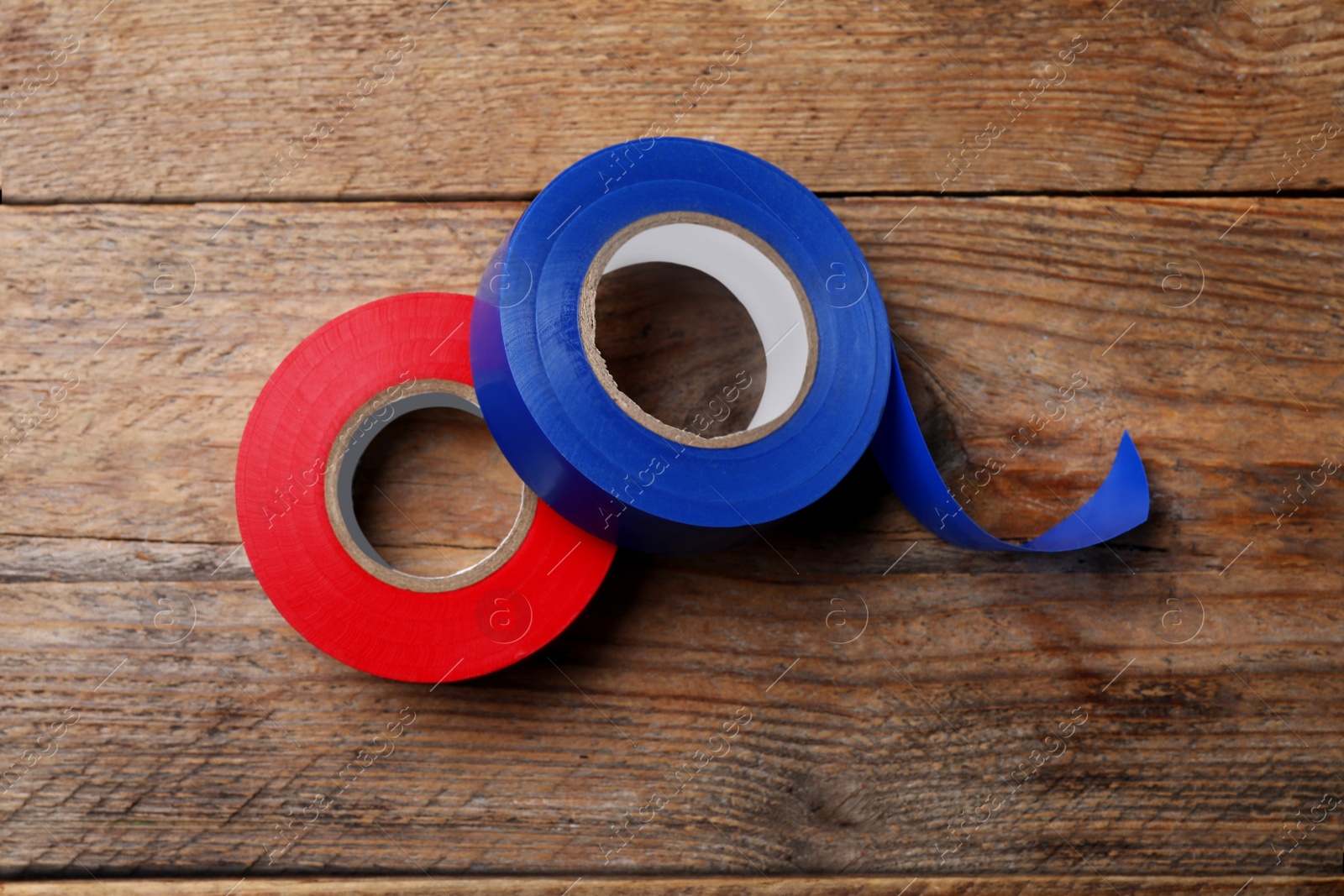 Photo of Colorful insulating tapes on wooden table, top view