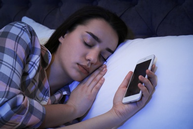 Lonely woman sleeping with smart phone in bed
