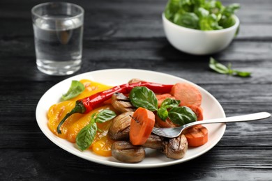 Photo of Delicious grilled vegetables on black wooden table