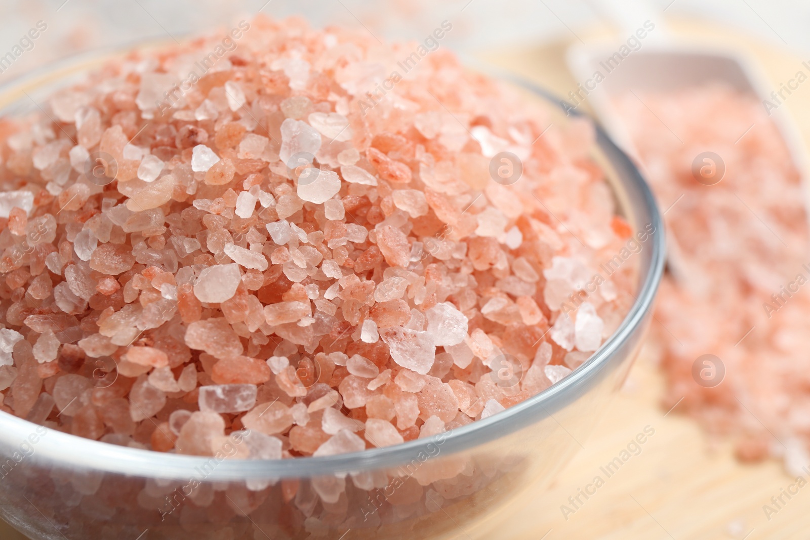 Photo of Pink himalayan salt in glass bowl on table, closeup