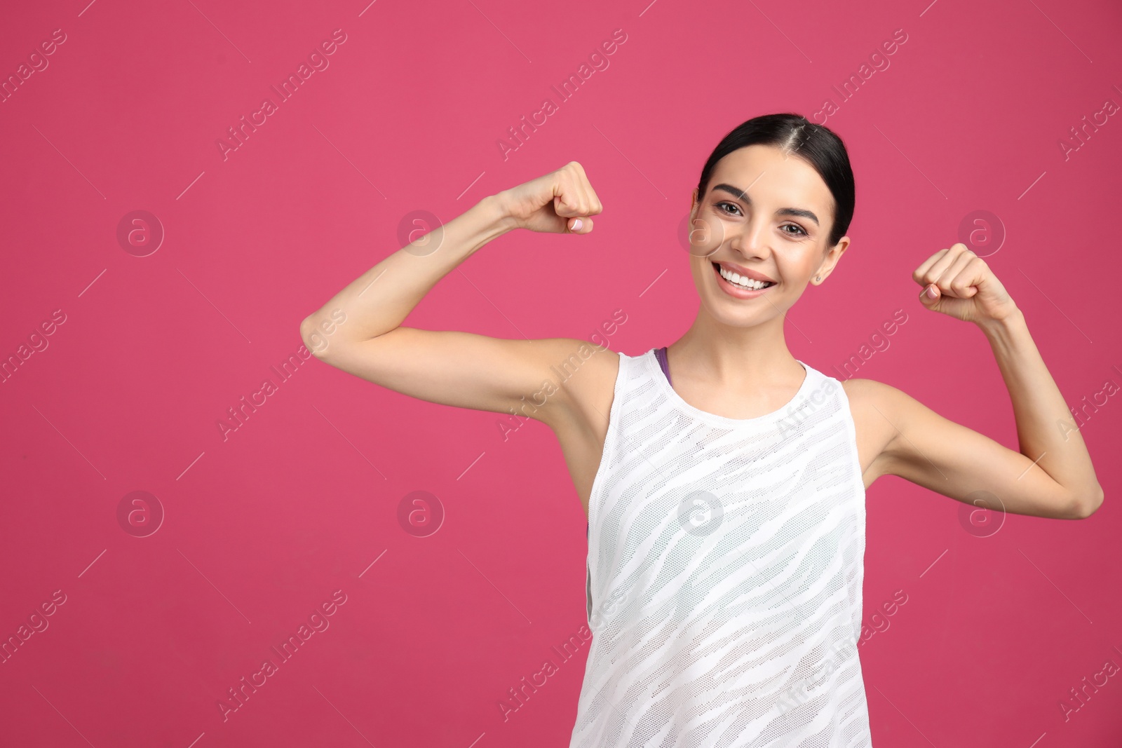 Photo of Strong woman as symbol of girl power on pink background. 8 March concept