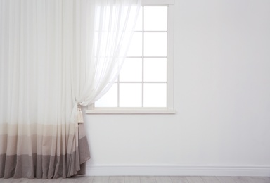Modern window with curtain in room, space for text. Home interior