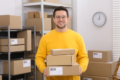 Photo of Seller with parcels in office. Online store