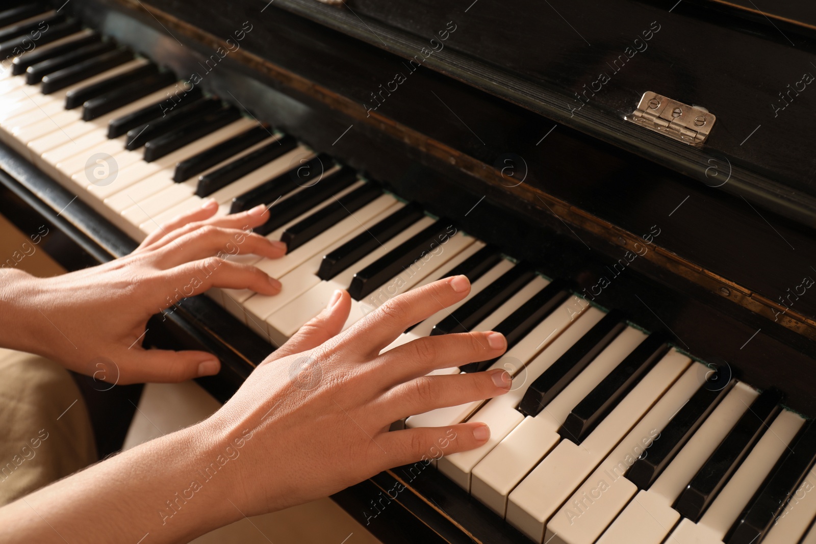 Photo of Young woman playing piano, closeup. Music lesson