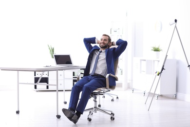 Young businessman sitting in comfortable office chair at workplace