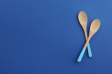 Photo of Clean bamboo spoons and space for text on color background, flat lay