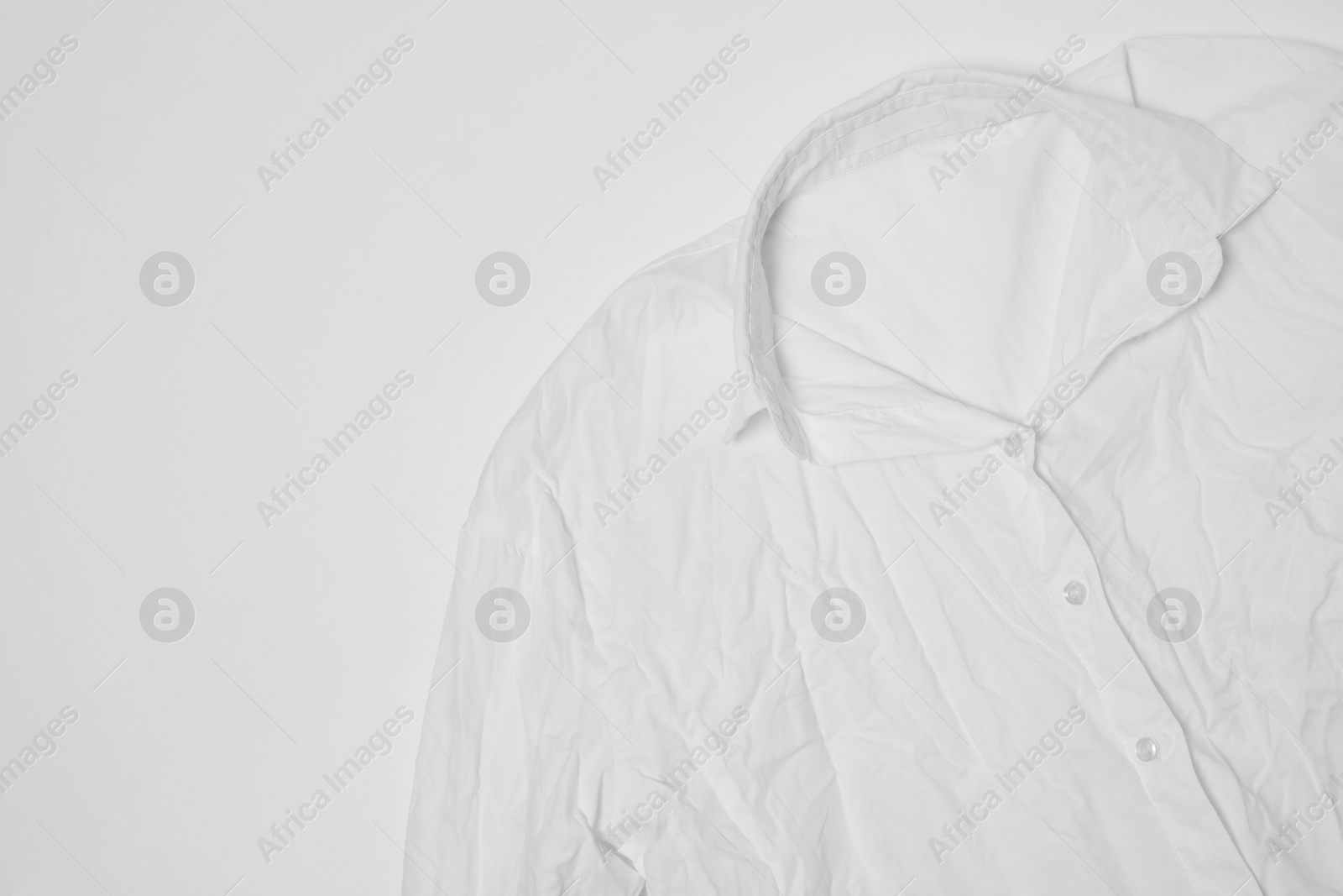 Photo of Crumpled shirt on white background, top view. Space for text