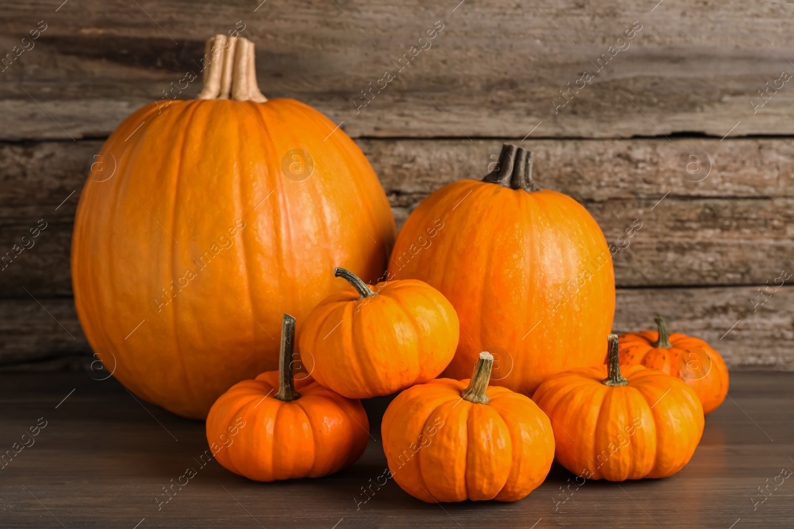 Photo of Pile of fresh ripe pumpkins on wooden table