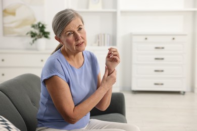 Arthritis symptoms. Woman suffering from pain in wrist at home