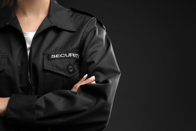 Photo of Female security guard in uniform on dark background, closeup