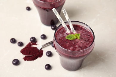 Photo of Glass with delicious acai smoothie on table, closeup