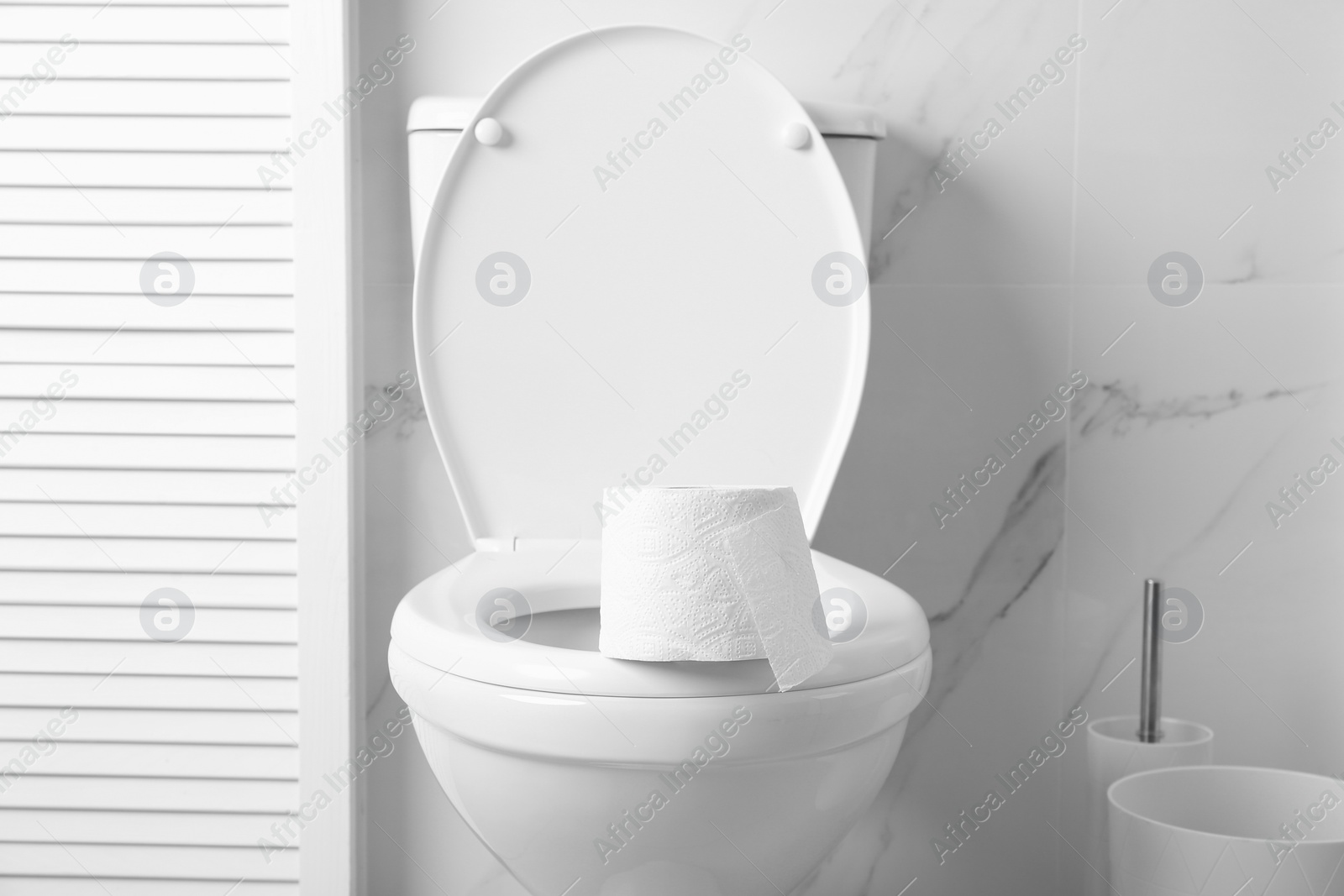 Photo of New paper roll on toilet bowl in bathroom