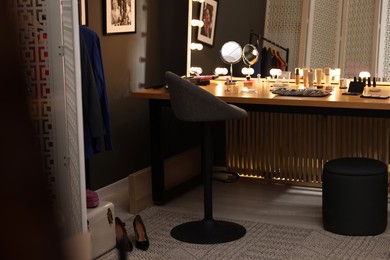 Makeup room. Stylish mirror on dressing table with different beauty products