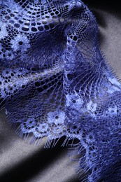 Beautiful blue lace on black fabric, top view