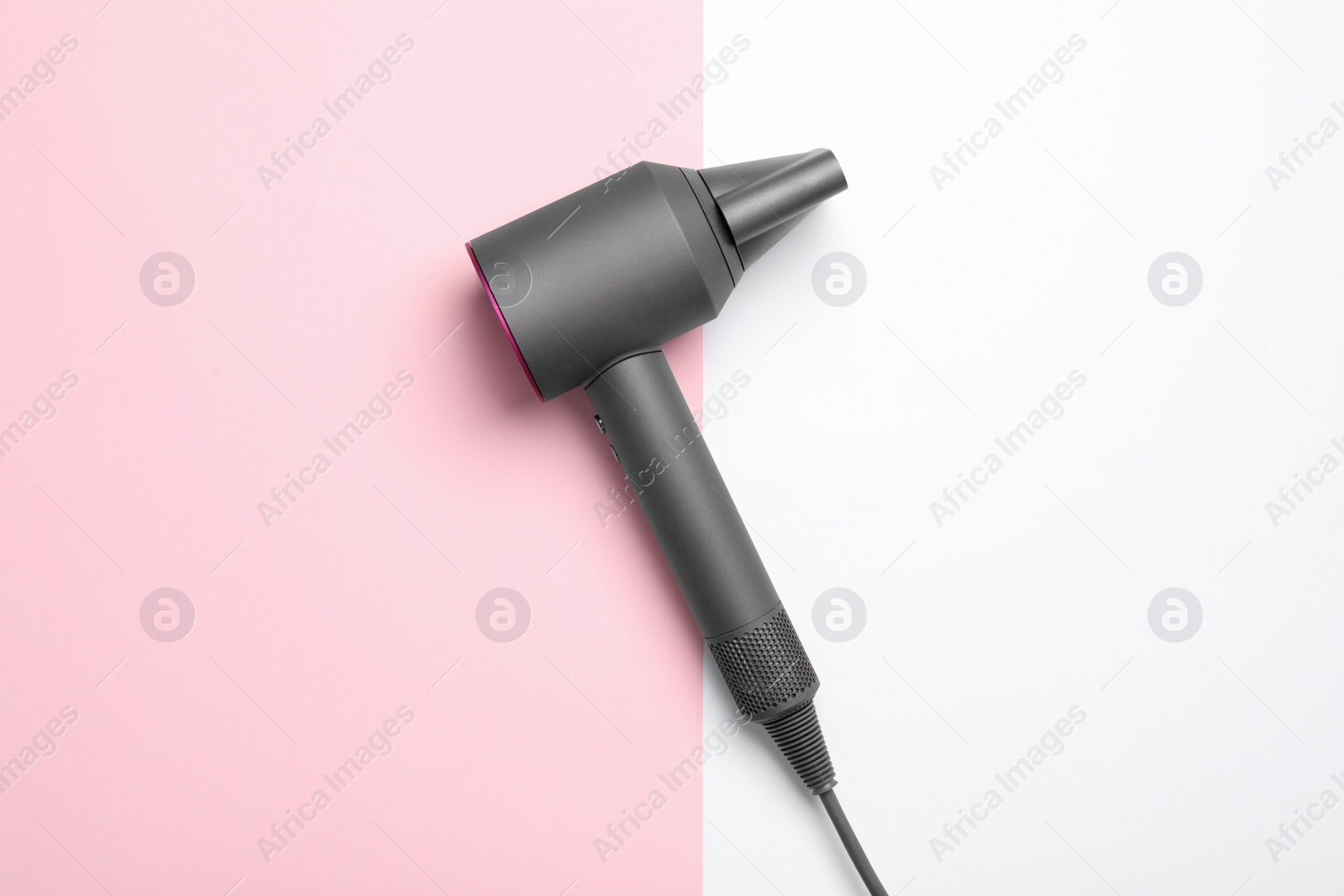 Photo of Hair dryer on color background, top view. Professional hairdresser tool