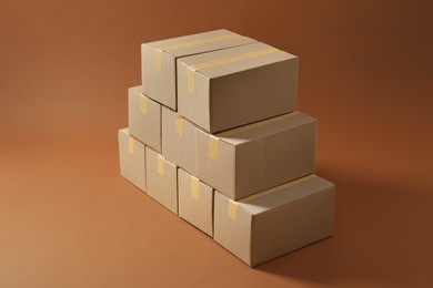 Photo of Stack of many cardboard boxes on brown background