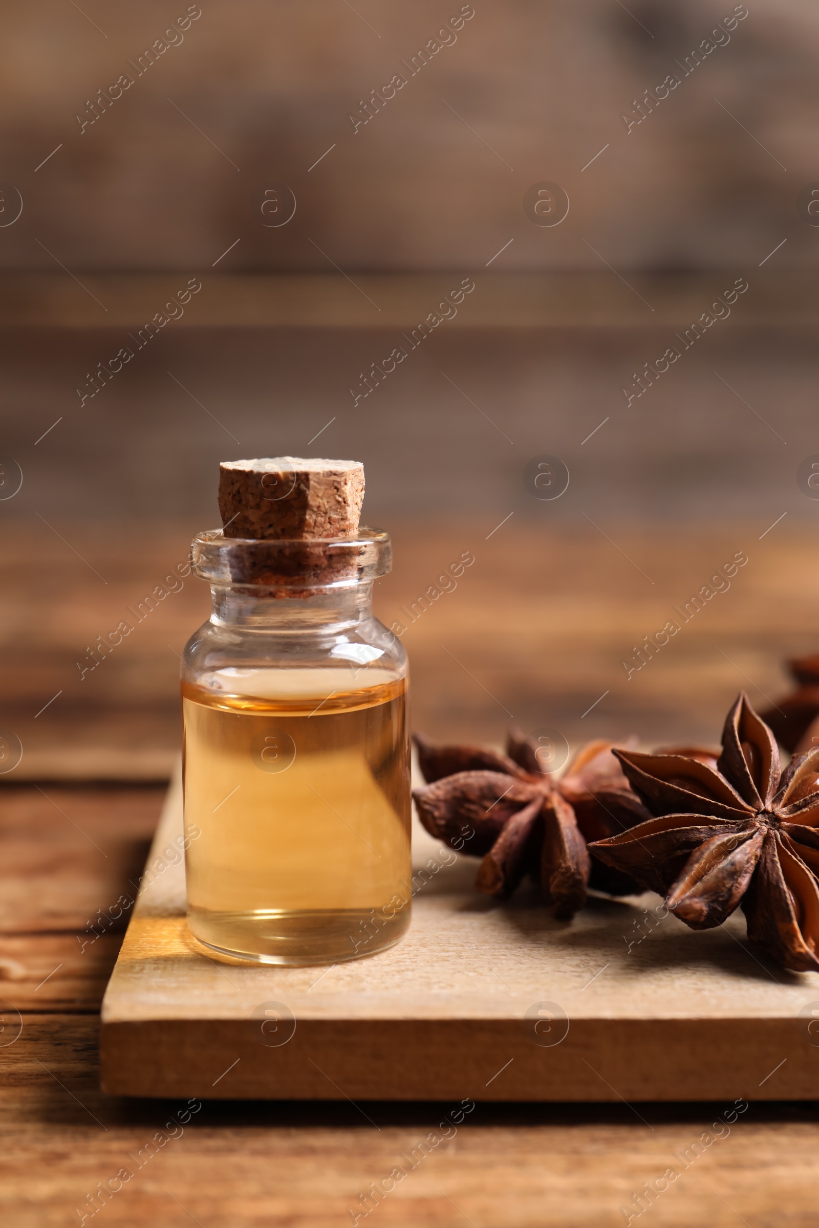 Photo of Bottle of essential oil and anise on wooden table