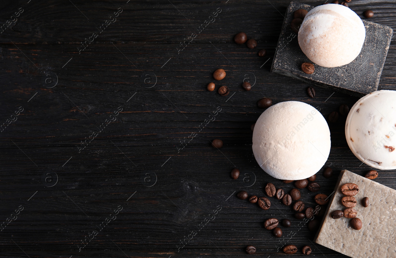 Photo of Flat lay composition with bath bombs, soap bars, coffee beans and space for text on wooden background