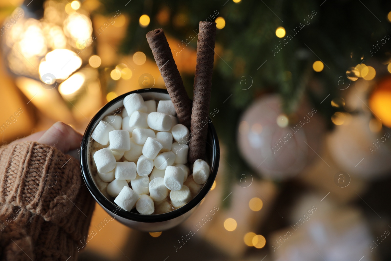 Photo of Woman with cup of cocoa indoors, top view. Christmas mood