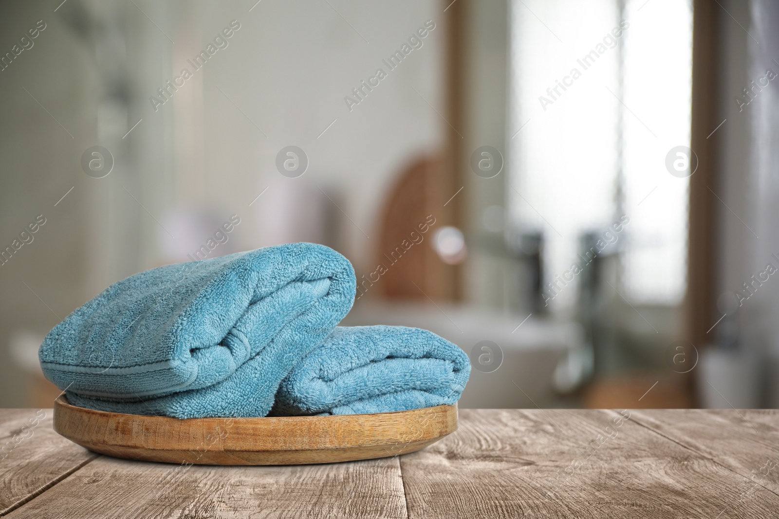 Image of Fresh towels on wooden table in bathroom. Space for text