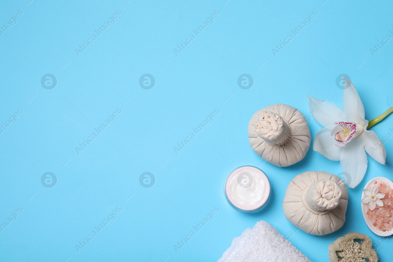 Photo of Flat lay composition with spa products and beautiful flower on light blue background. Space for text