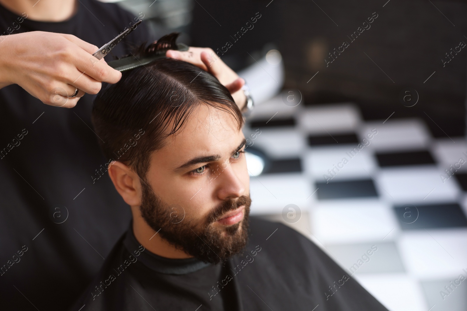 Photo of Professional hairdresser working with client in barbershop