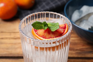 Photo of Delicious refreshing drink with sicilian orange and mint on wooden table, closeup