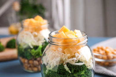 Photo of Healthy salad in glass jar on table, closeup