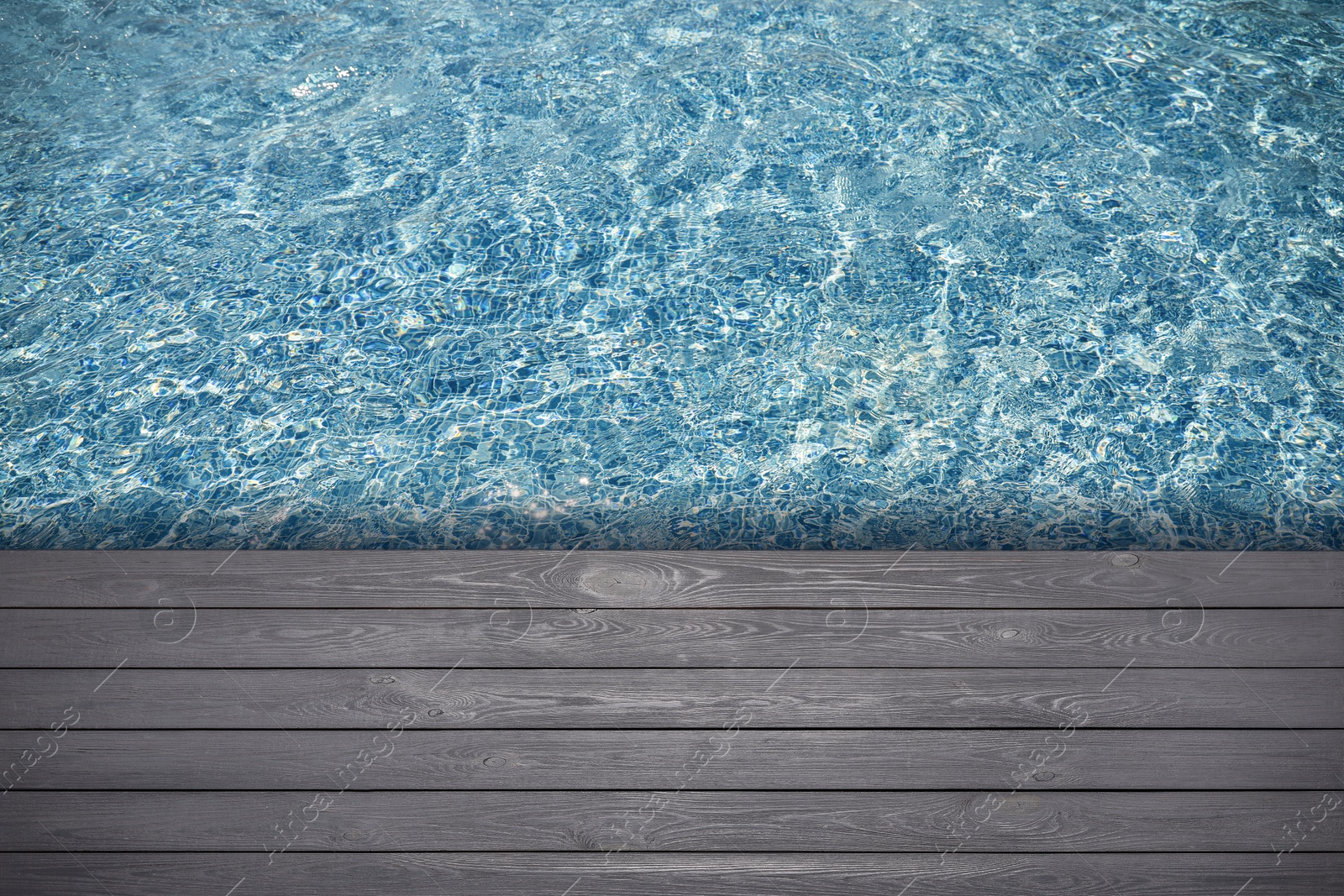 Image of Empty grey wooden surface near swimming pool with clear water. Space for design