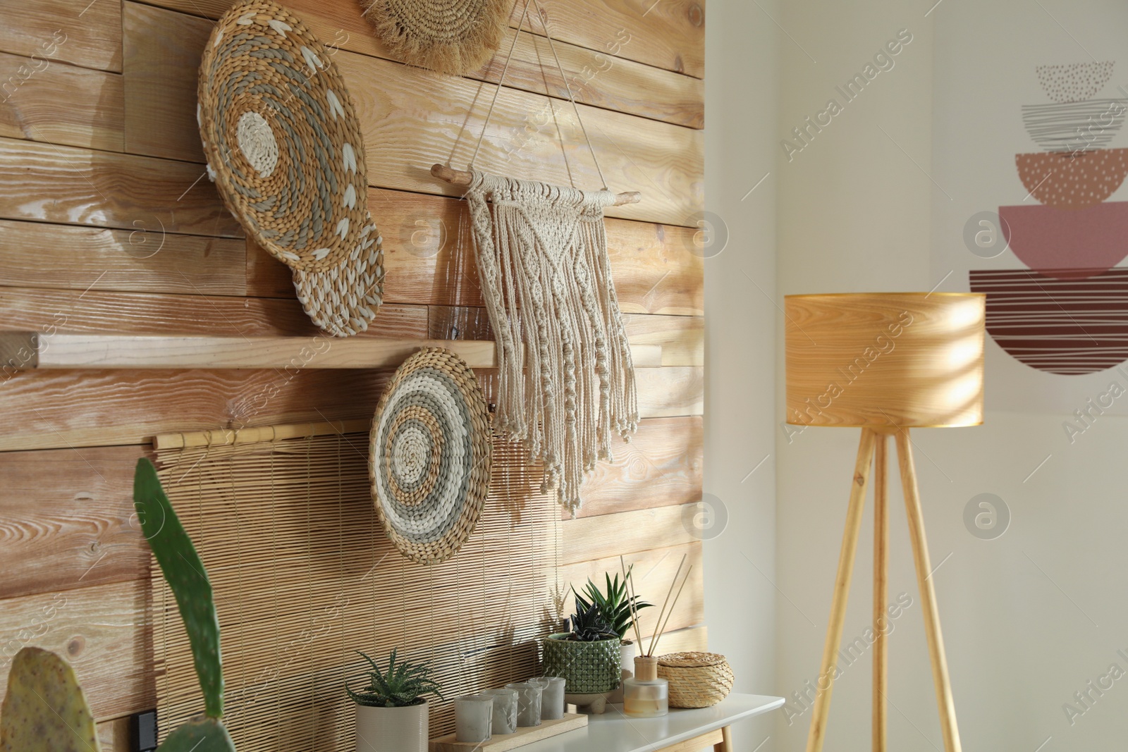 Photo of Different decorative elements on wooden wall indoors. Interior design
