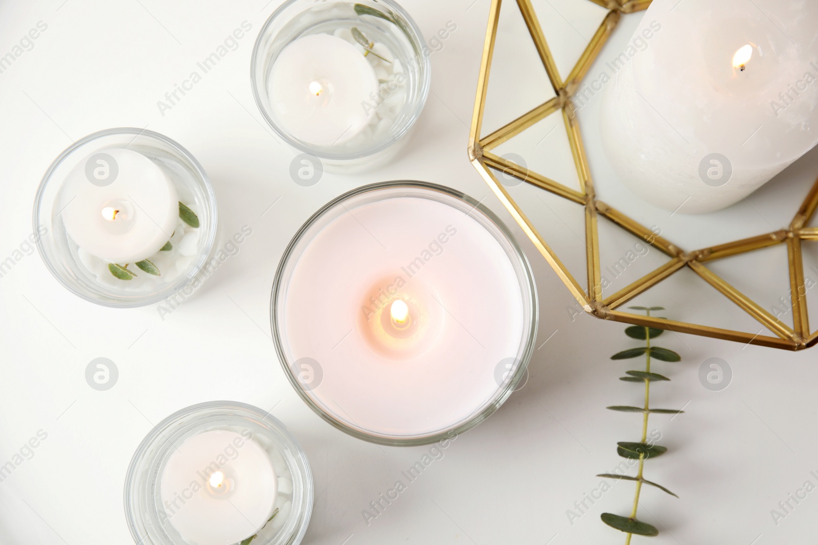 Photo of Flat lay composition with burning aromatic candles and eucalyptus on white table